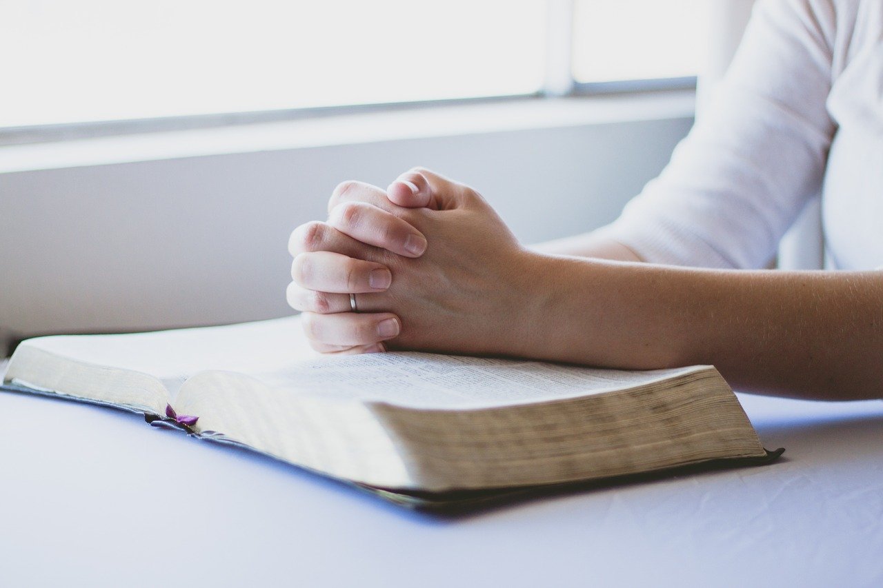 betende Hände auf Bibel