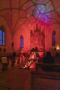 Kirchenraum rot beleuchtet mit Sternenhimmel