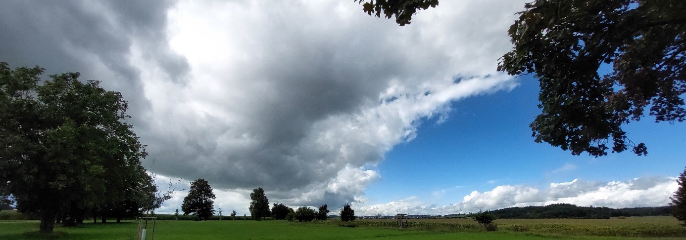 große Wolken mit grünem Feld