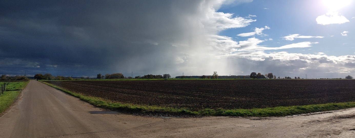 Feldwege mit Acker und hellem und dunklem Himmel