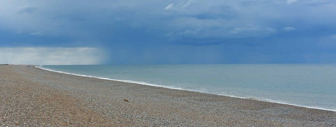Strand-Wasser und Regenwolken